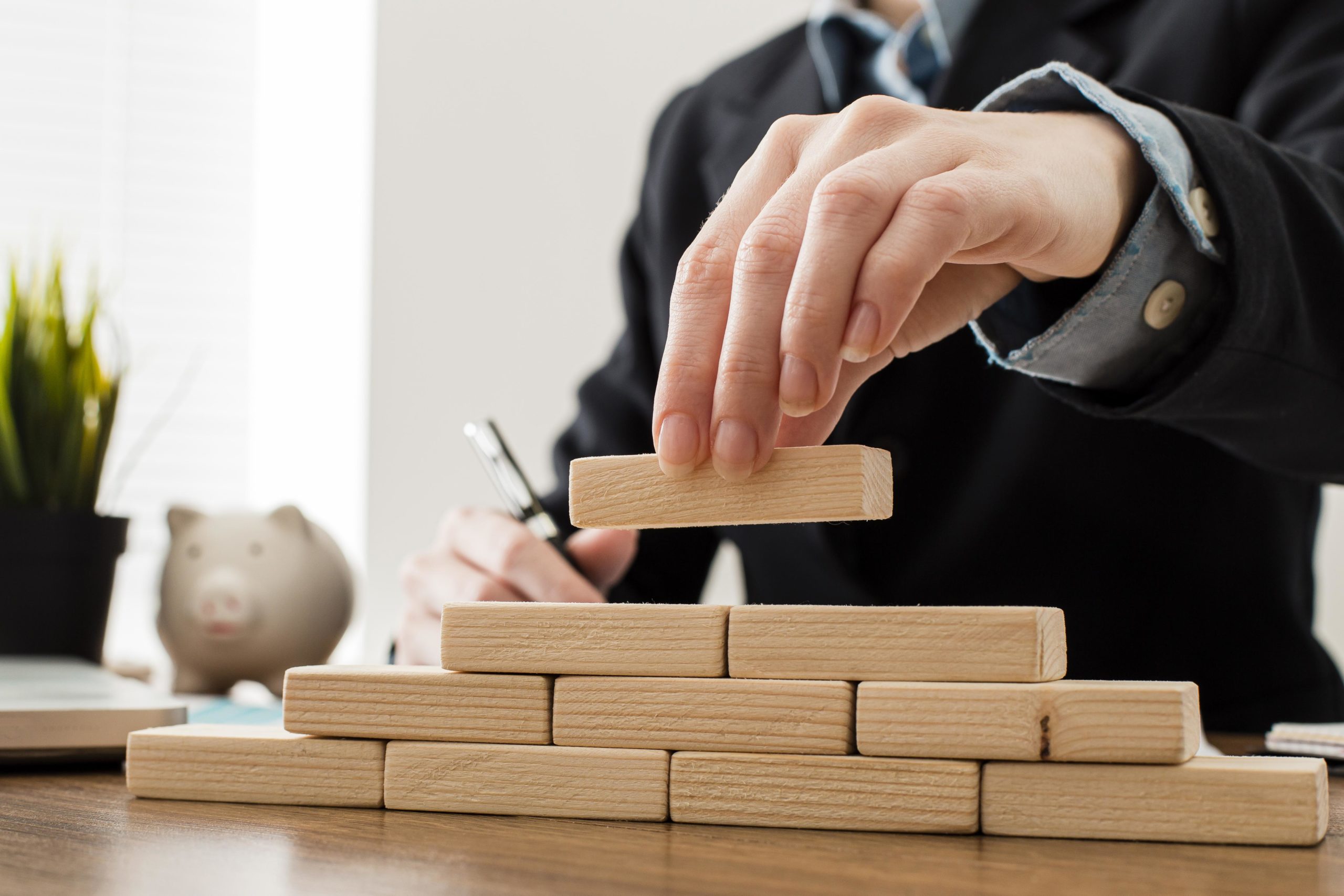 front-view-businessman-with-wooden-building-blocks (1)
