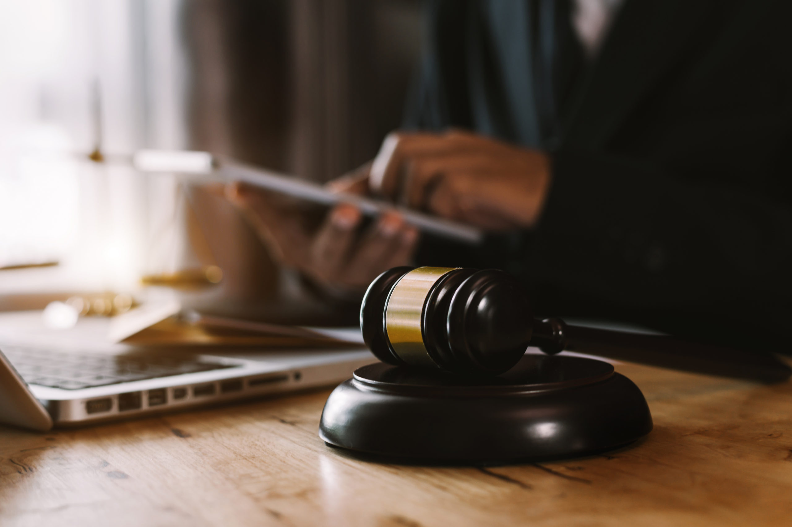 justice and law concept.Male judge in a courtroom on wooden table and Counselor or Male lawyer working in office. Legal law, advice and justice concept.